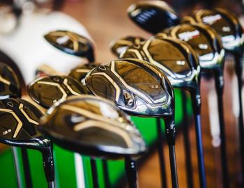 Shiny golf clubs on display in a pro shop