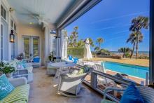 Vacation rental patio with private pool and ocean view in background