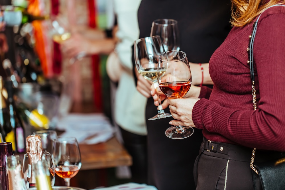 Two women holding wine glasses at a tasting event